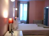 Comfort Double room seen from the headboard toward the curtained window, radiator and chair